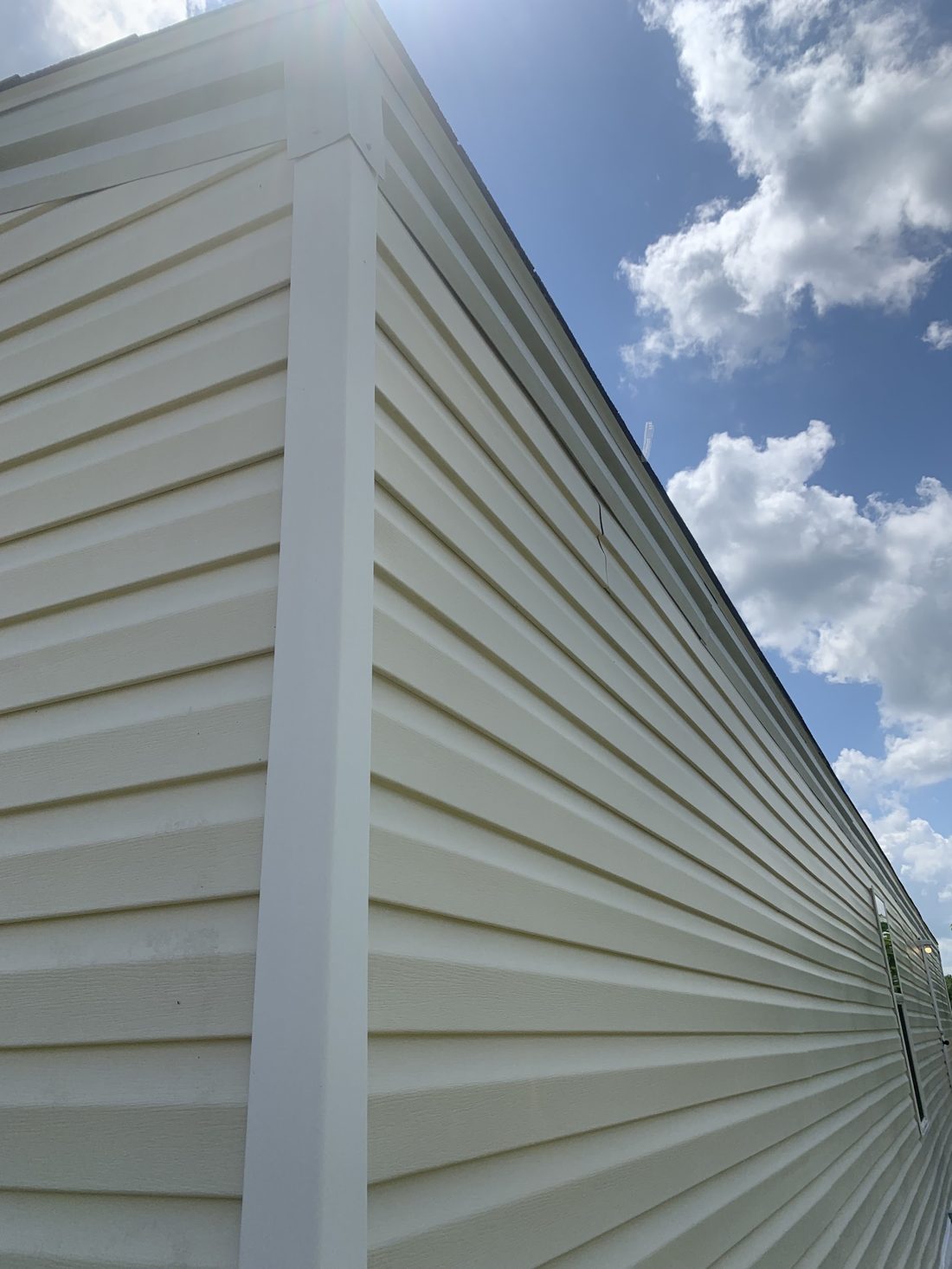 Washed vinyl siding along the corner of a long wall